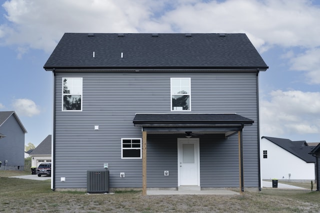 rear view of house featuring a shingled roof and central AC unit