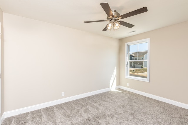 carpeted spare room with a ceiling fan, visible vents, and baseboards