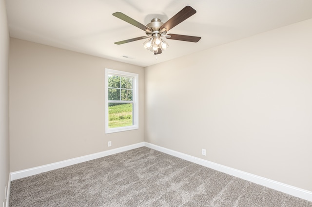 carpeted spare room with baseboards, visible vents, and ceiling fan