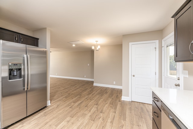 kitchen with light hardwood / wood-style flooring, appliances with stainless steel finishes, dark brown cabinets, a notable chandelier, and decorative light fixtures