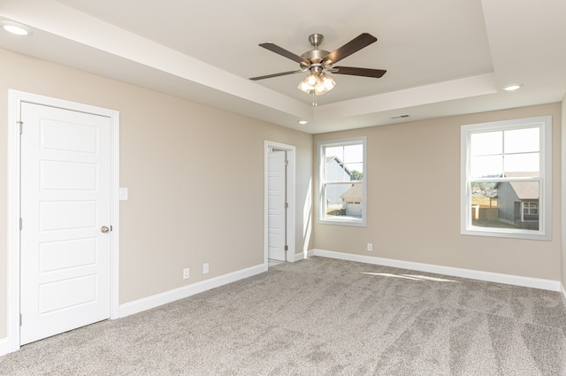 carpeted spare room featuring recessed lighting, a raised ceiling, a ceiling fan, and baseboards