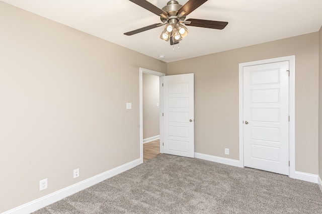 unfurnished bedroom with light colored carpet, ceiling fan, and baseboards