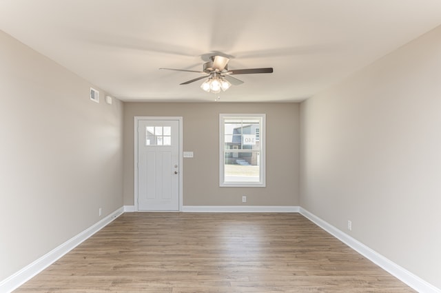 foyer entrance with ceiling fan and light hardwood / wood-style floors