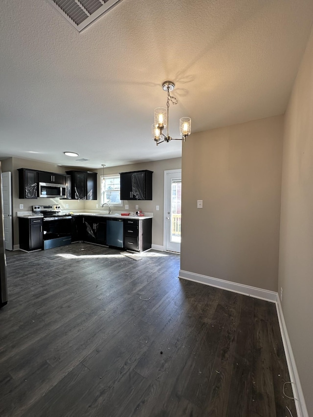 kitchen featuring appliances with stainless steel finishes, hanging light fixtures, a notable chandelier, a textured ceiling, and dark hardwood / wood-style flooring