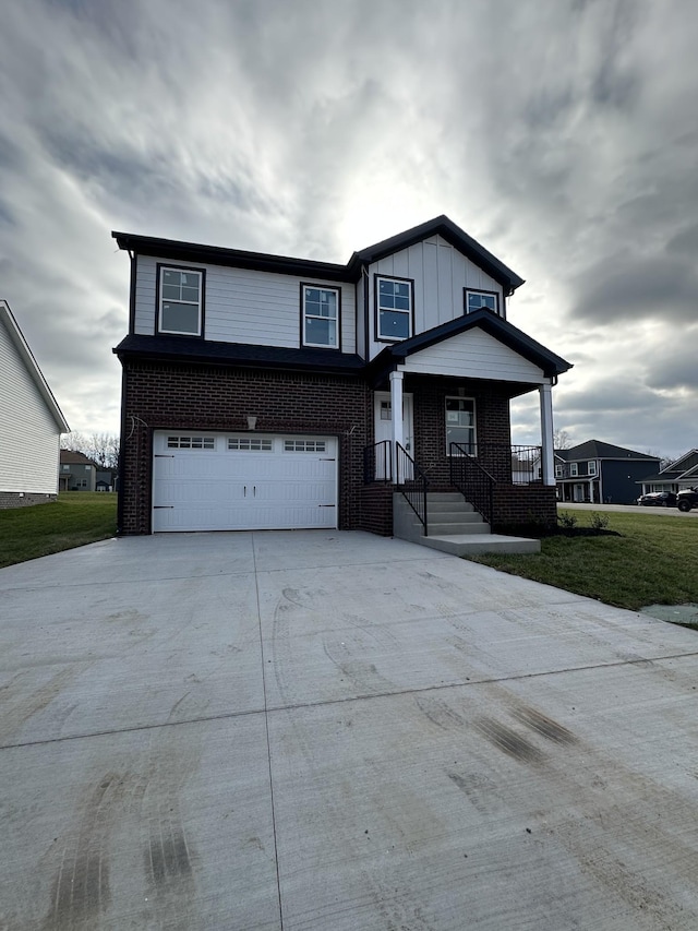 view of front of property featuring a garage, driveway, brick siding, and board and batten siding