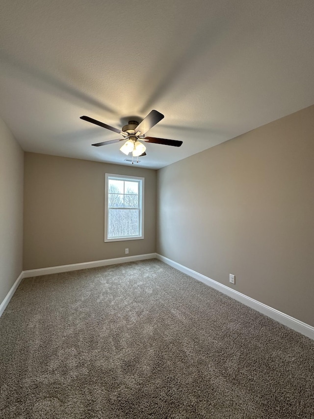 unfurnished room with carpet floors, ceiling fan, baseboards, and a textured ceiling