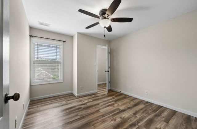 unfurnished bedroom featuring dark wood-type flooring and ceiling fan