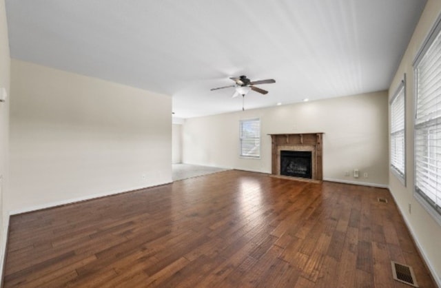 unfurnished living room with ceiling fan and dark hardwood / wood-style flooring