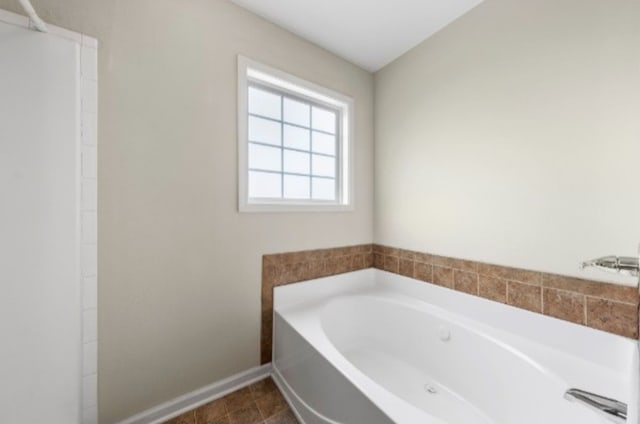 bathroom with tile patterned flooring and a tub