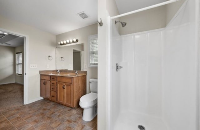 bathroom with walk in shower, vanity, toilet, and a wealth of natural light