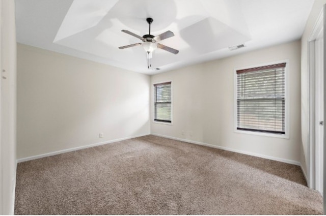 unfurnished room featuring ceiling fan, carpet floors, and a tray ceiling