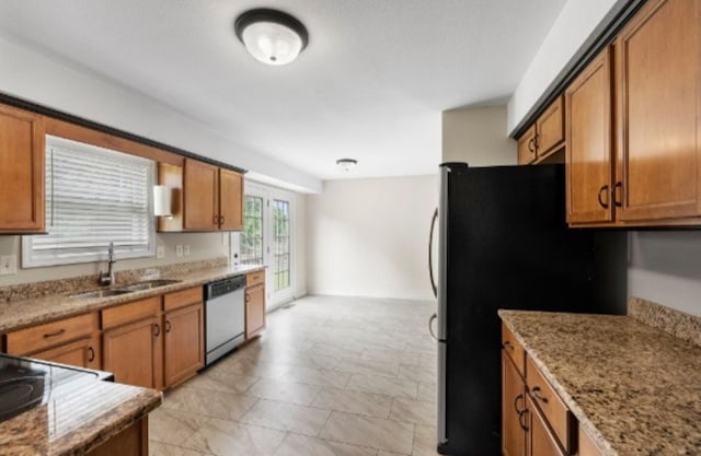 kitchen with light stone countertops, stainless steel appliances, and sink