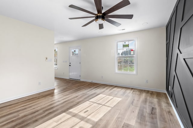 empty room with light wood-type flooring and ceiling fan