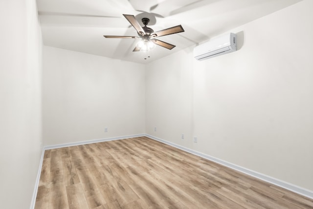 empty room with light wood-type flooring, a wall mounted air conditioner, and ceiling fan