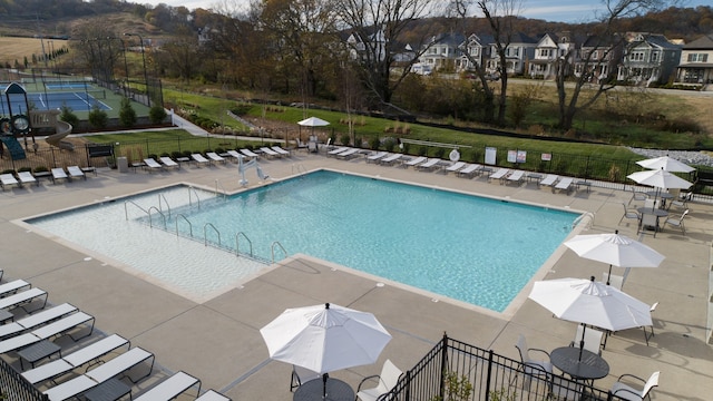 view of pool featuring a patio and a yard