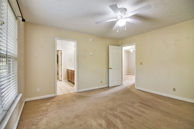 unfurnished room with a textured ceiling, light colored carpet, and ceiling fan