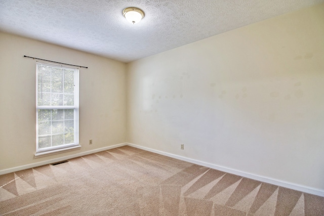 unfurnished room with carpet flooring and a textured ceiling