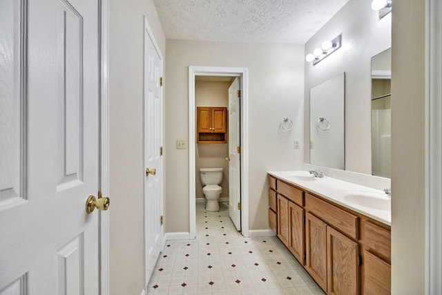 bathroom featuring vanity, toilet, and a textured ceiling