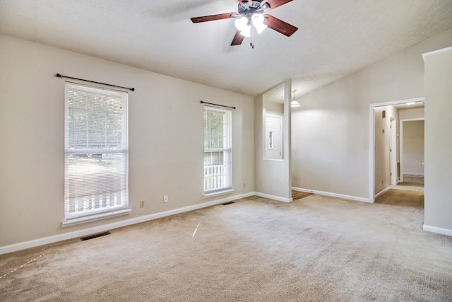 carpeted empty room with lofted ceiling, a textured ceiling, and ceiling fan