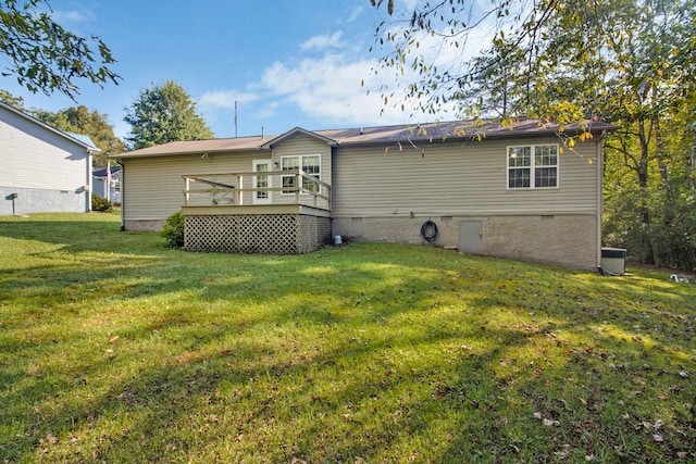 rear view of house featuring a lawn and a deck