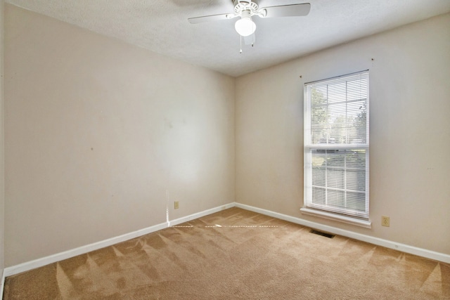 unfurnished room with light colored carpet and ceiling fan