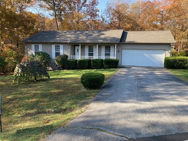 single story home featuring a front lawn and a garage