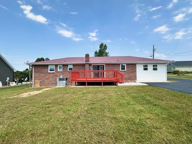 exterior space with a deck, a front lawn, and central AC unit