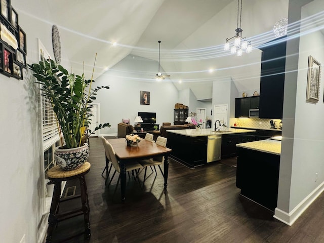 kitchen with pendant lighting, a kitchen island with sink, dark wood-type flooring, appliances with stainless steel finishes, and decorative backsplash