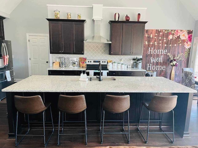 kitchen with appliances with stainless steel finishes, a center island with sink, and dark wood-type flooring