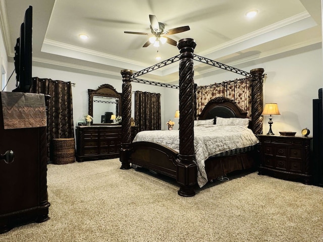 carpeted bedroom featuring crown molding, a tray ceiling, and ceiling fan