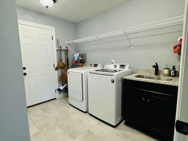 laundry area with cabinets, washer and dryer, and sink