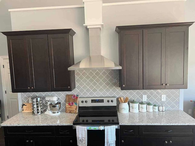 kitchen with dark brown cabinetry, stainless steel range with electric stovetop, wall chimney range hood, and decorative backsplash