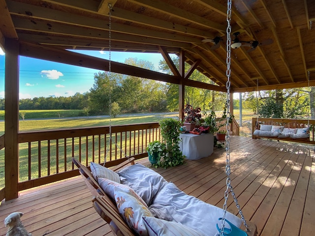 wooden terrace featuring a lawn and ceiling fan