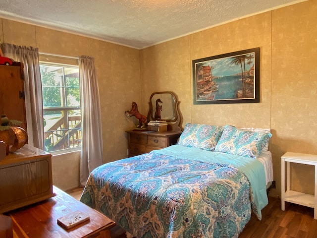 bedroom with a textured ceiling and dark wood-type flooring