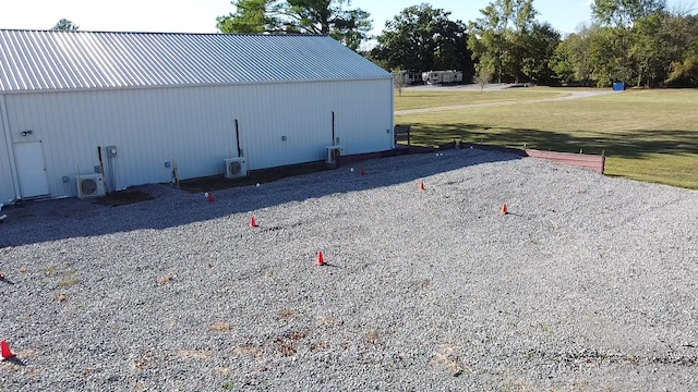 view of outdoor structure with a lawn and ac unit