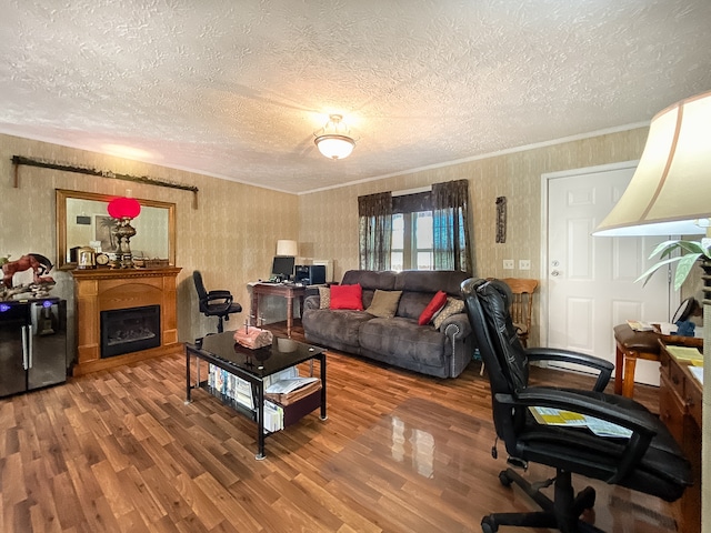 living room featuring a textured ceiling, hardwood / wood-style floors, and crown molding