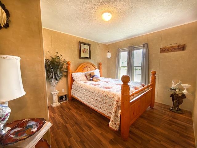 bedroom featuring a textured ceiling and dark hardwood / wood-style floors