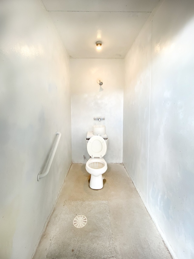 bathroom featuring concrete floors and toilet