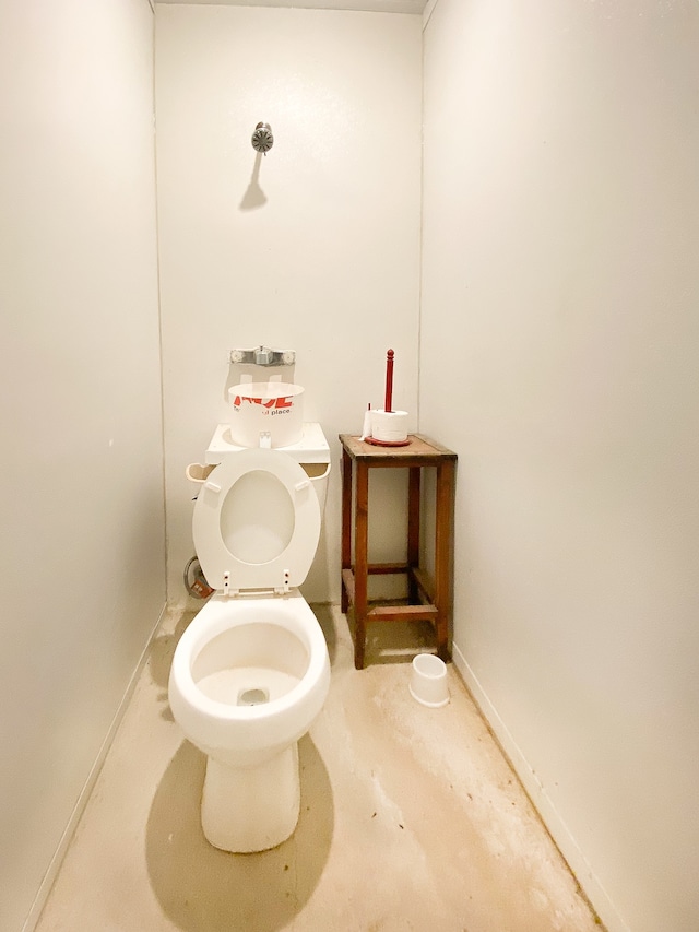 bathroom featuring concrete floors and toilet