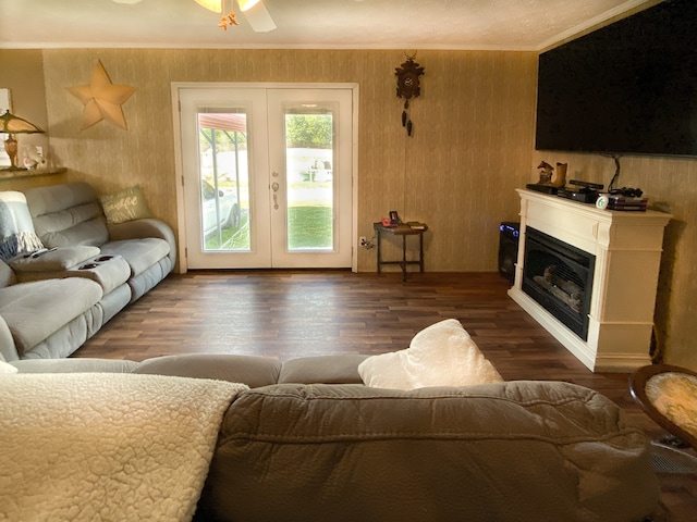 living room with wooden walls, ceiling fan, dark hardwood / wood-style floors, and french doors