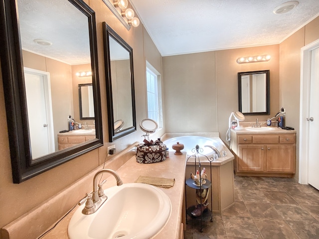 bathroom featuring vanity, a tub to relax in, a textured ceiling, and tile patterned floors