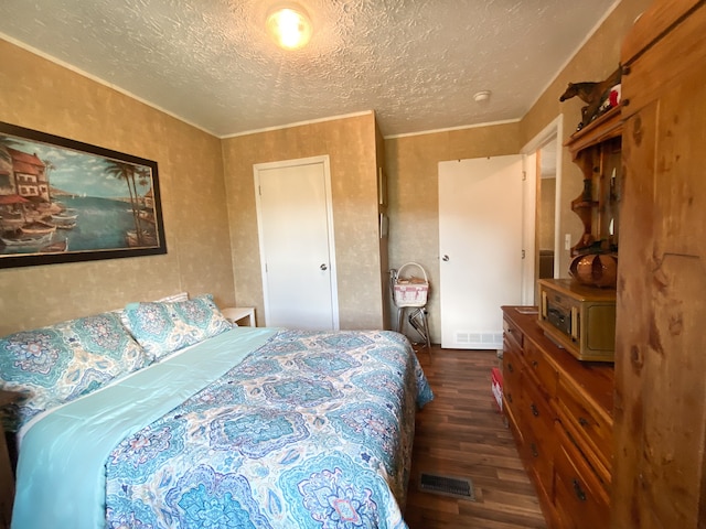 bedroom with a textured ceiling and dark wood-type flooring