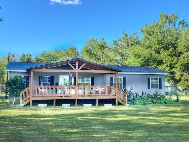 rear view of house featuring a deck and a lawn