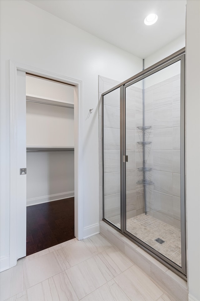 bathroom with hardwood / wood-style flooring and a shower with shower door