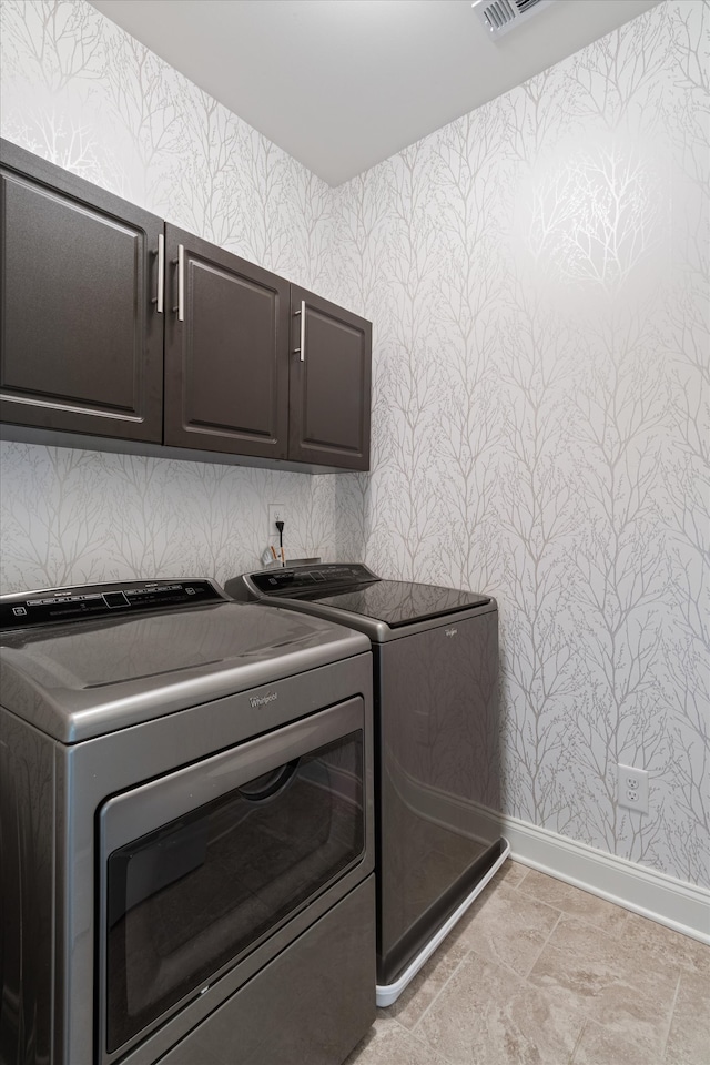 washroom featuring independent washer and dryer and cabinets