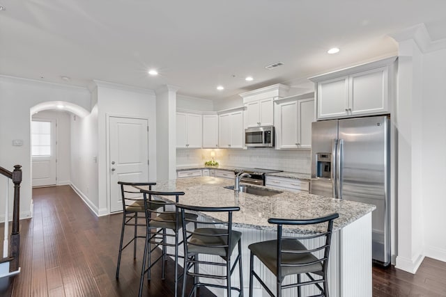 kitchen with stainless steel appliances, white cabinetry, dark wood-type flooring, and sink