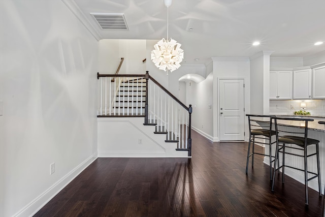 dining space featuring an inviting chandelier, dark hardwood / wood-style floors, and ornamental molding