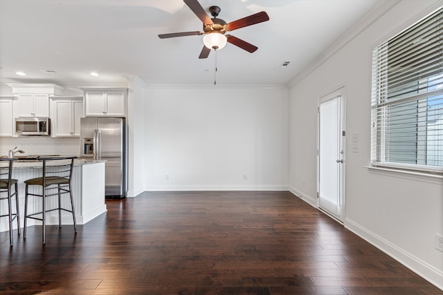 unfurnished living room with ceiling fan, dark hardwood / wood-style floors, and ornamental molding