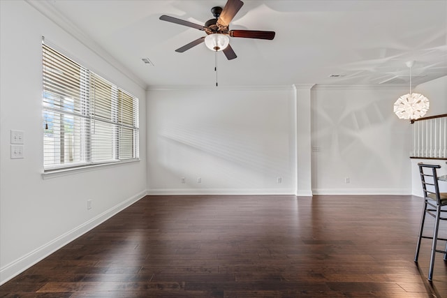 spare room featuring ceiling fan with notable chandelier, dark wood-type flooring, and crown molding