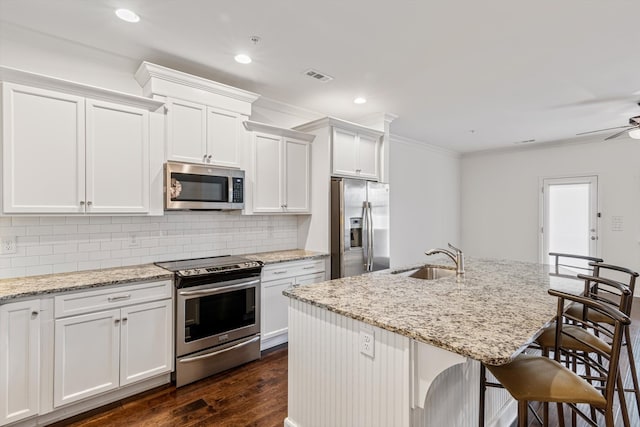 kitchen featuring ceiling fan, white cabinets, sink, a kitchen island with sink, and appliances with stainless steel finishes